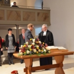 übergibt die Einsetzungsurkunde.